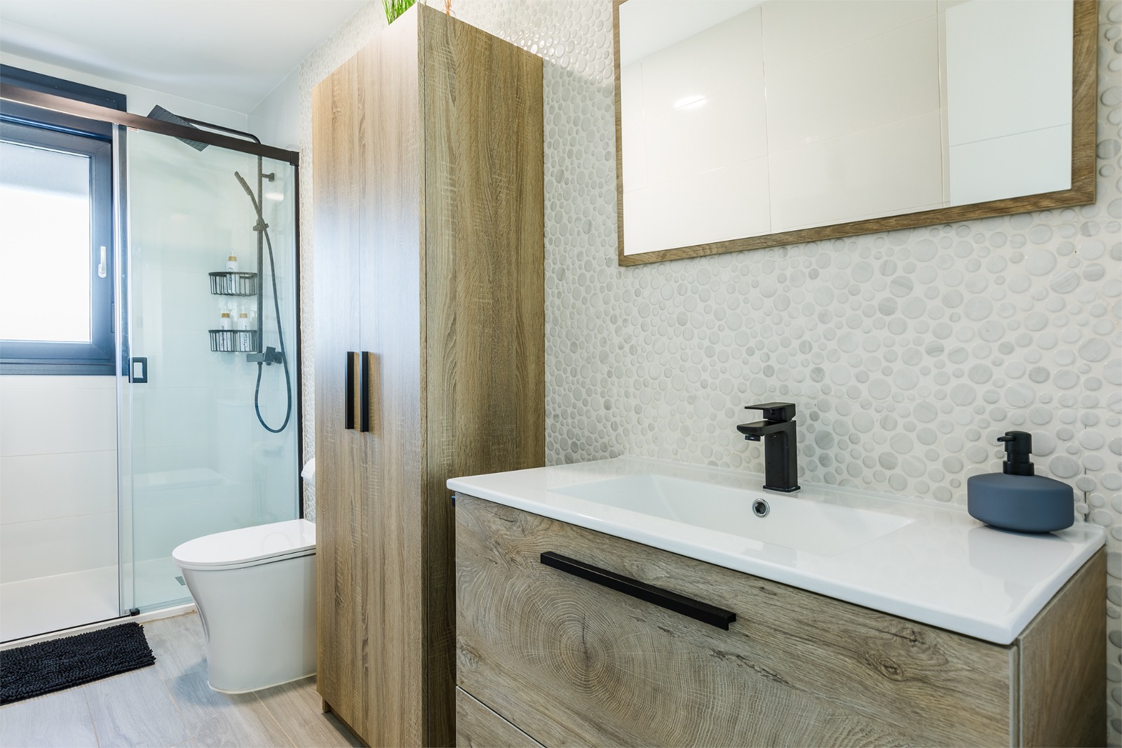 Baño completo con ducha, inodoro, columna de madera y lavabo con espejo