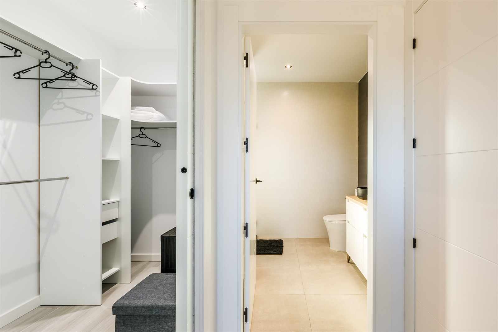 Vestidor con perchero y acceso al baño en suite