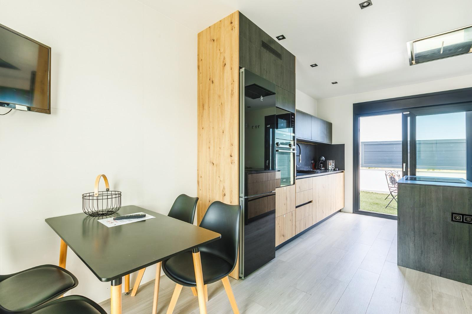 Cocina de diseño en madera y negro con isla, comedor y salida a la terraza