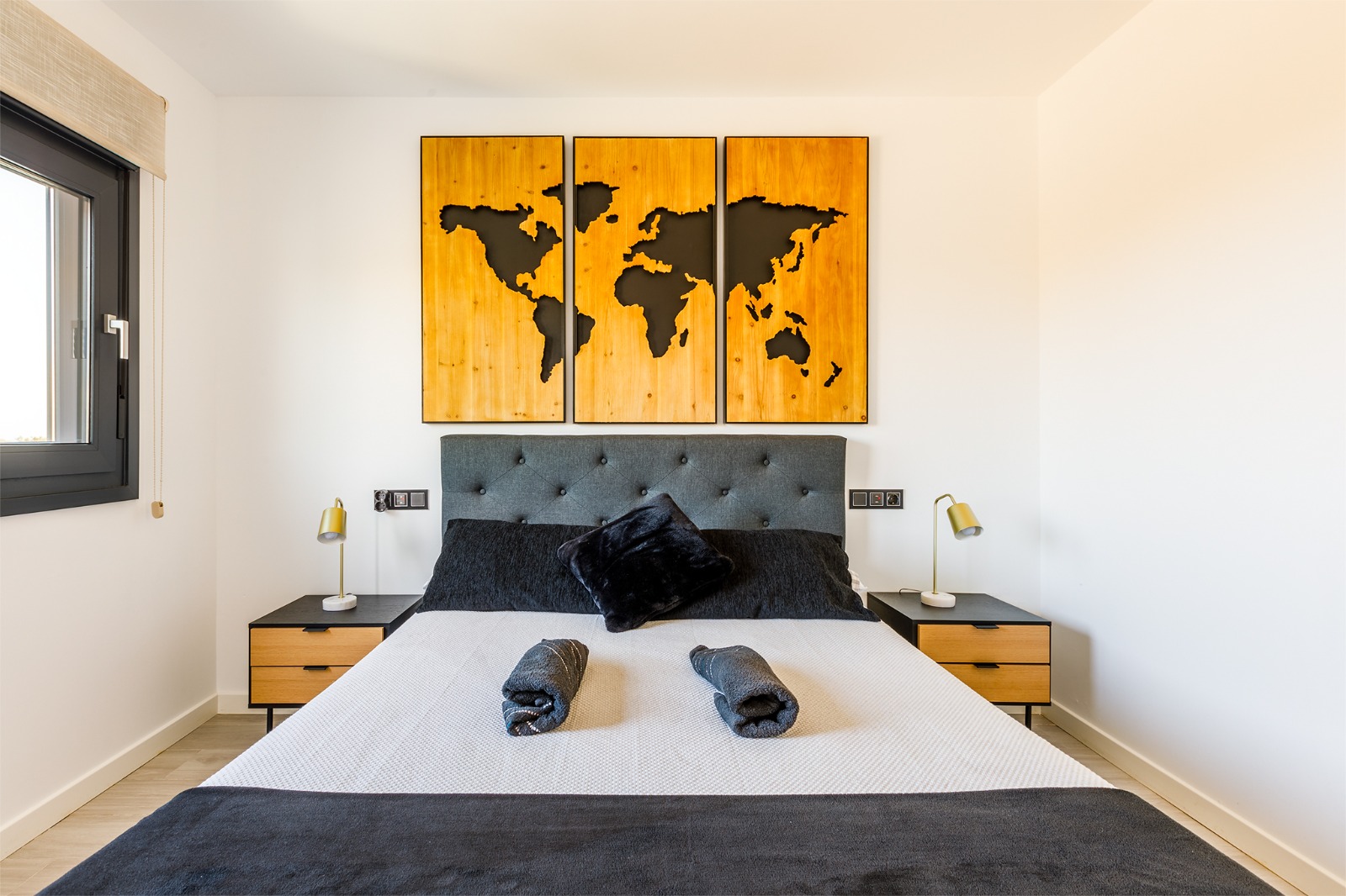 Dormitorio con cama doble, cómoda de madera y salida a la terraza