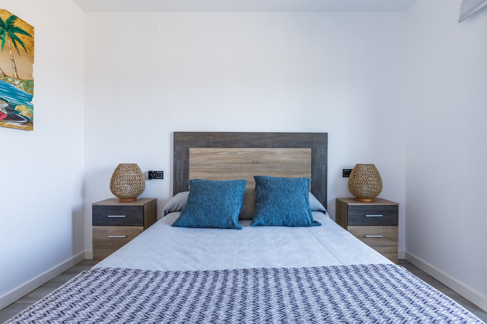 Dormitorio con aire acondicionado, cómoda de madera y cama doble