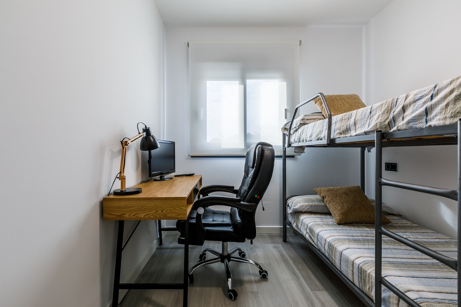 Dormitorio con litera, burro para la ropa con perchas y salida al pasillo