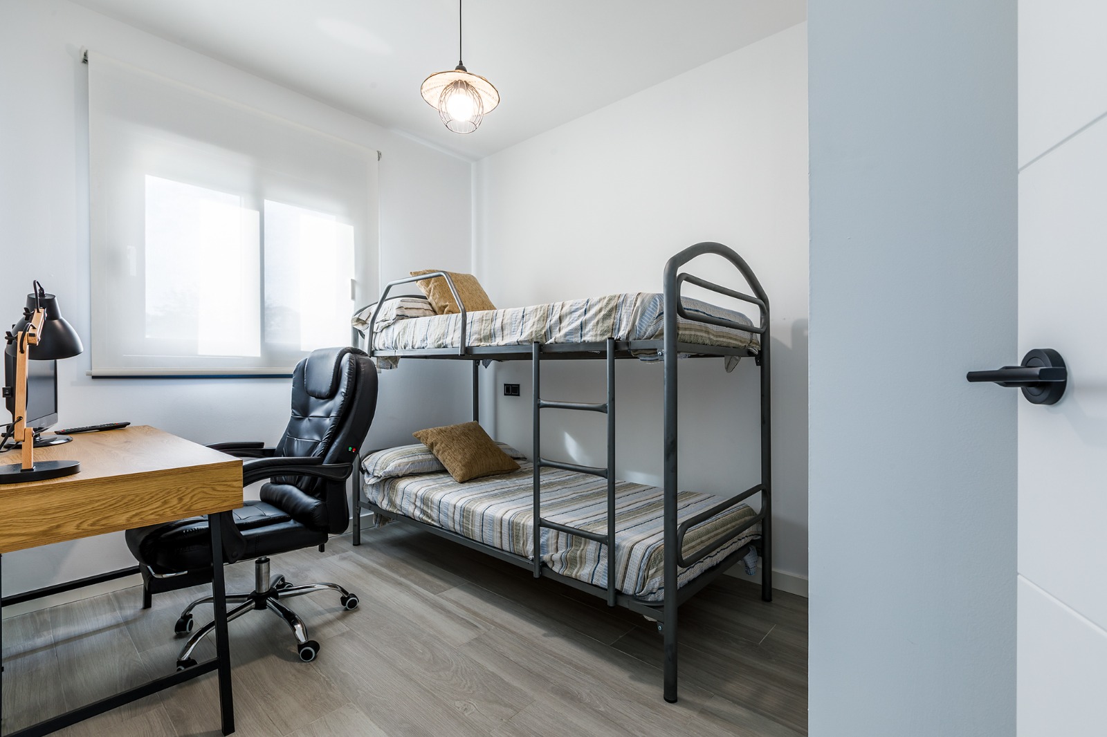 Dormitorio principal con cama doble, cabecero capitoné y mapamundi de madera