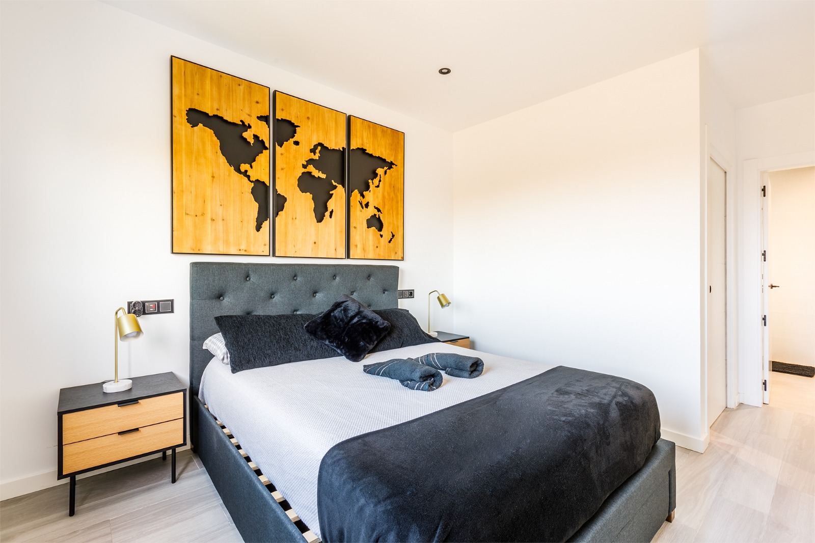 Dormitorio principal con vistas al campo, mapamundi de madera y mesitas de noche