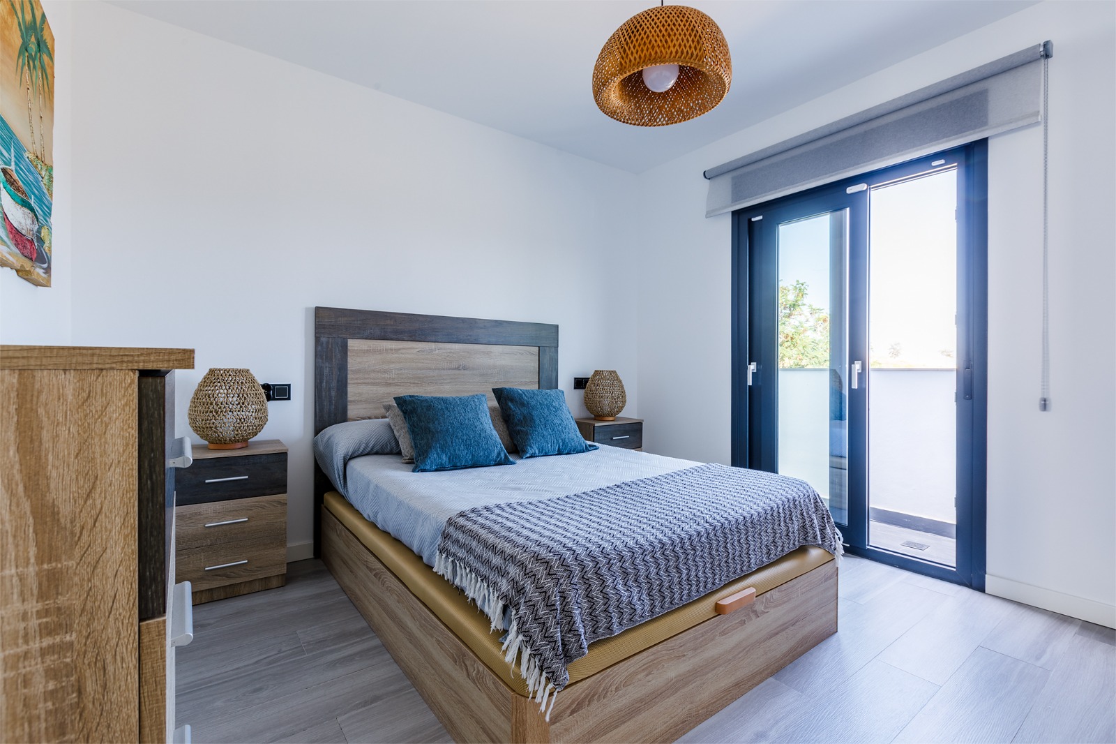 Dormitorio principal con cama doble, cabecero capitoné y mapamundi de madera