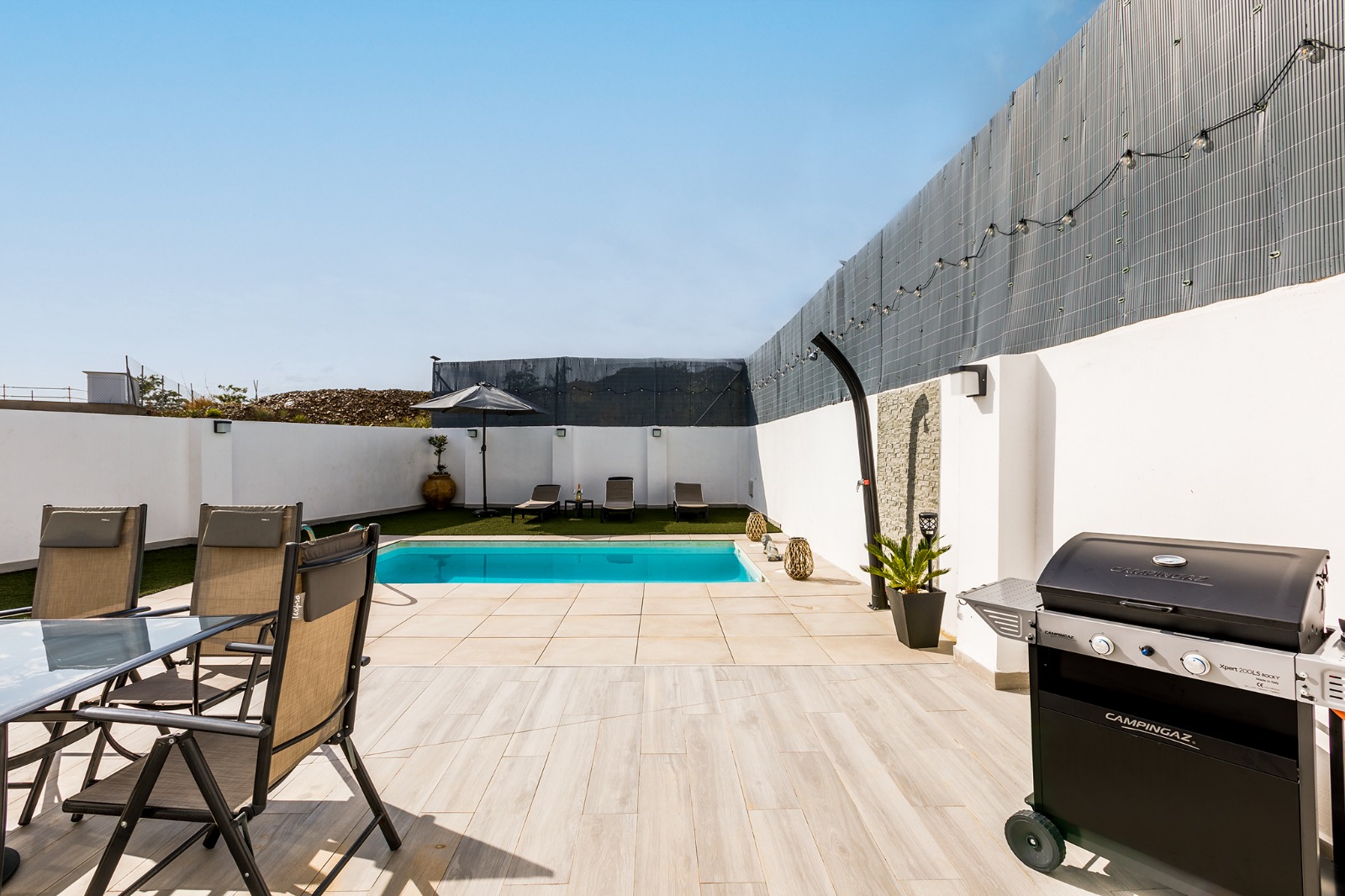 Solárium con tumbonas, comedor exterior y barbacoa