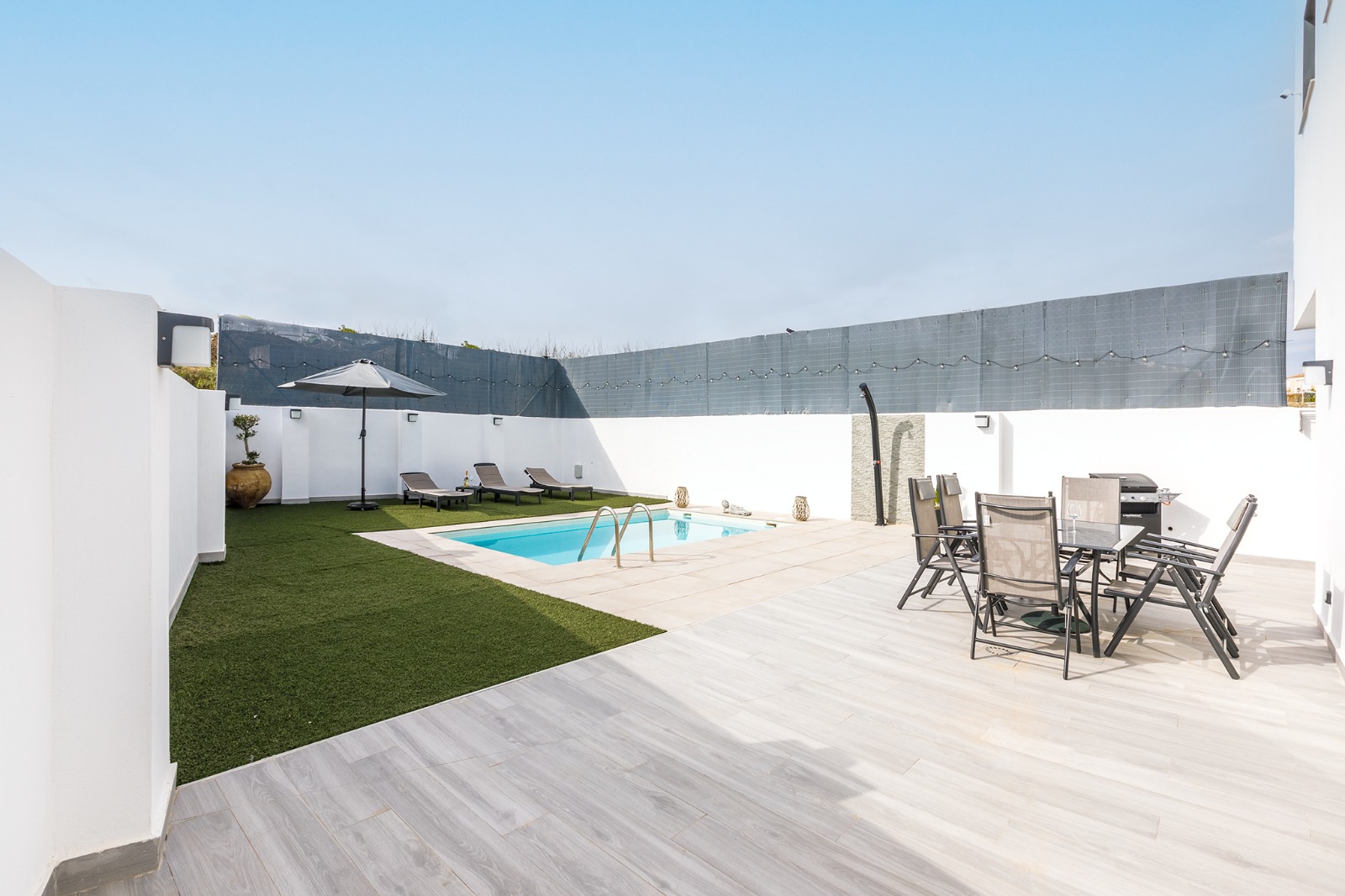 Terraza amplia con comedor exterior junto a la piscina