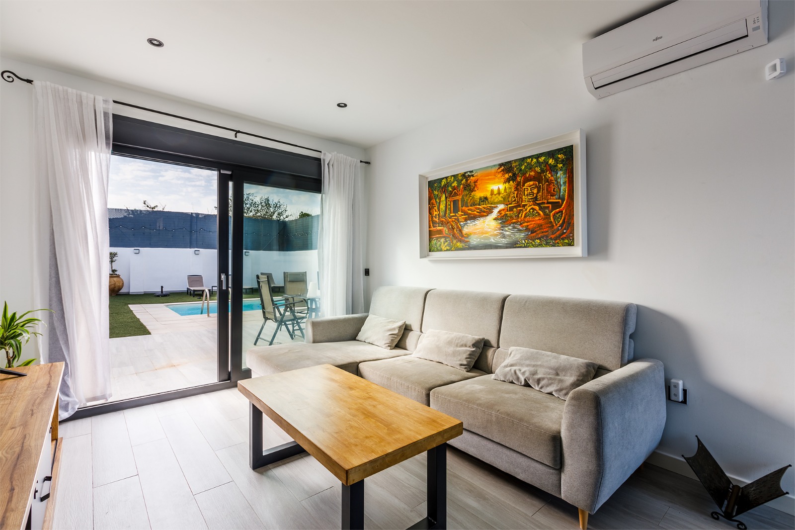 Salón con sofá y salida directa a la piscina y el jardín